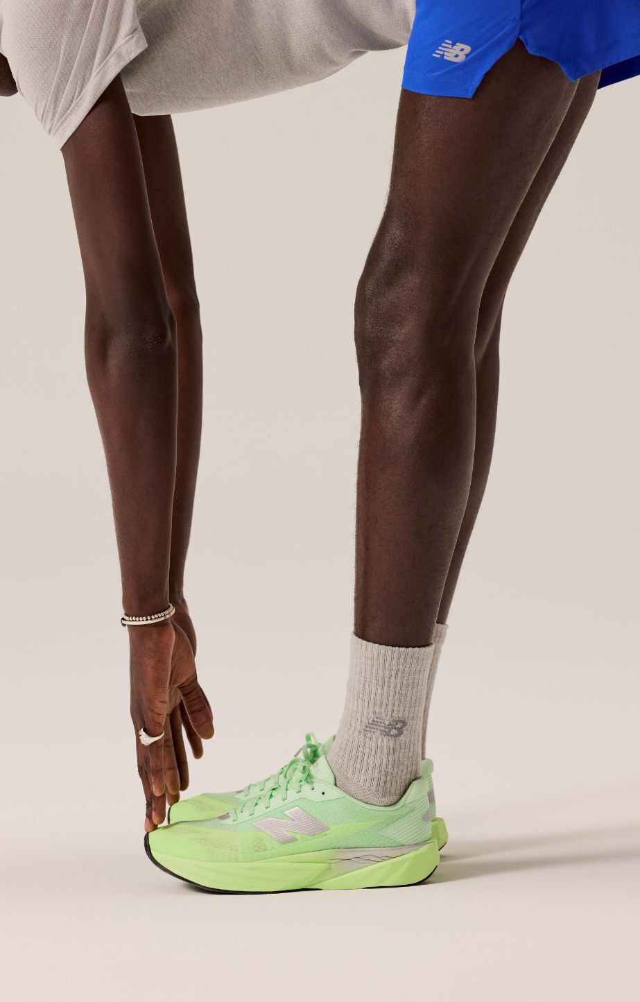 man stretching in a studio, wearing new balance rebel v5s